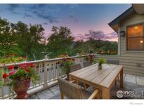 Enjoy sunsets from this inviting patio with a wooden dining set and mountain views at 1521 Mapleton Ave, Boulder, CO 80304