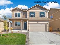 Two-story house with tan siding, gray shutters, and a two-car garage at 2257 Base St, Fort Lupton, CO 80621