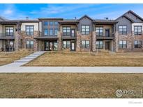 Attractive townhouses showing stone accents, balconies, individual entryways, and well manicured lawns at 255 High Point Dr # 204, Longmont, CO 80504