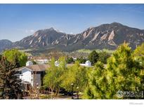 Scenic view of Flatirons mountains overlooking townhomes and lush greenery under a bright blue sky at 2938 Kalmia Ave # 6, Boulder, CO 80301