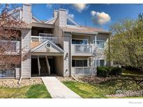 Exterior view of a multi-story home featuring a walkway, balcony, and manicured landscaping with blue skies above at 4840 Twin Lakes Rd # 7, Boulder, CO 80301