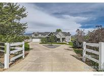 Stunning two-story home with a circular driveway and a well-manicured front yard at 7401 Deerfield Rd, Longmont, CO 80503