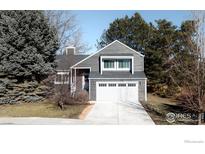 Gray two-story house with white garage door and landscaping at 886 Osprey Ct, Louisville, CO 80027