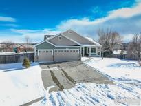 Two-story house with three-car garage and snowy front yard at 1885 Parkdale Ct, Erie, CO 80516