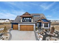 Two-story home with a large wooden garage door and landscaped front yard at 2648 Bluewater Rd, Berthoud, CO 80513