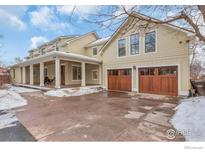 Two-story house with a large front porch, attached two-car garage, and snow-covered driveway at 1430 Balsam Ave, Boulder, CO 80304