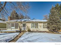 Ranch style home with snow covered yard and picket fence at 2253 Columbine Ave, Boulder, CO 80302
