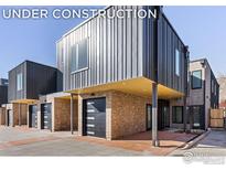 Modern townhome exterior featuring brick and metal siding with black garage doors at 3319 Broadway St, Boulder, CO 80304