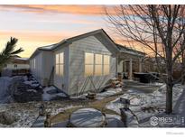 Charming home with backyard patio, landscaping, and snow-covered walkway at 6539 Empire Ave, Frederick, CO 80516
