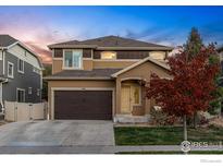 Two-story house with brown accents, attached garage, and landscaping at 105 Indian Peaks Dr, Erie, CO 80516