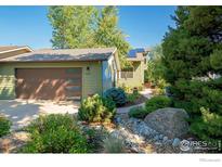 Green two-story house with a brown garage door and landscaped yard at 1095 Quince Ave, Boulder, CO 80304