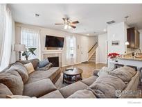 Spacious living room featuring a cozy fireplace and ample natural light at 12794 Leyden St # A, Thornton, CO 80602