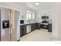 Bright kitchen featuring stainless appliances, white cabinets, and modern finishes at 12802 E Nevada Cir, Aurora, CO 80012