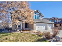 Two-story house with a three-car garage and landscaping at 1486 Clover Creek Dr, Longmont, CO 80503