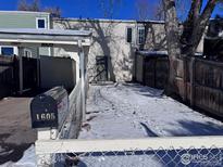 Backyard view of the property with snow and a fenced area at 1605 Longbow Ct, Lafayette, CO 80026