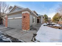 Gray two-story home with brick accents and a two-car garage at 3537 W 125Th Cir, Broomfield, CO 80020