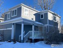 Two-story gray house with white trim, covered porch, and snowy yard at 5526 Friends Pl, Boulder, CO 80303