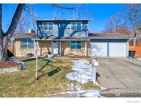 Ranch style home with attached two-car garage and landscaped yard at 8267 Quay Ct, Arvada, CO 80003