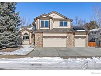 Two-story house with three-car garage and snow-covered front yard at 839 W Mahogany Cir, Louisville, CO 80027