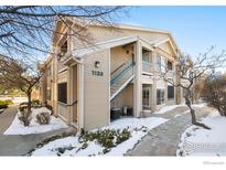 Exterior view of a light beige building with a snowy walkway at 1138 Opal St # 101, Broomfield, CO 80020