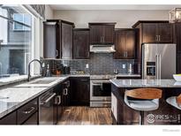 Modern kitchen features dark cabinetry, granite countertops, and stainless steel appliances at 12387 W 51St Ave, Wheat Ridge, CO 80033