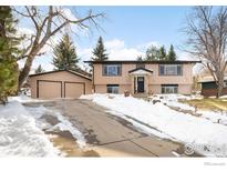 Ranch style home with attached two-car garage and snow-covered driveway at 1382 Glen Ct, Boulder, CO 80305