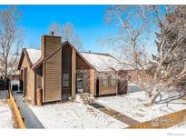 Ranch style home with wood siding, stone accents, and a snow covered yard at 245 Cedar St, Hudson, CO 80642