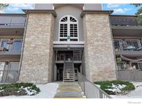 Exterior view of a two-story condo building with stone accents and a staircase at 2575 S Syracuse Way # E-302, Denver, CO 80231