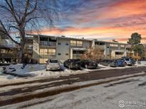 Complex of snow covered townhouses with parking and mountain views at sunset at 2707 Valmont Rd # 307D, Boulder, CO 80304