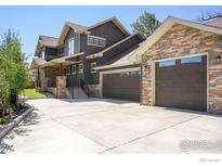 Two-story home with stone and siding accents, three-car garage, and landscaped front yard at 313 S 3Rd Ave, Superior, CO 80027