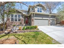 Two-story house with gray siding, stone accents, and a two-car garage at 3424 W Torreys Peak Dr, Superior, CO 80027