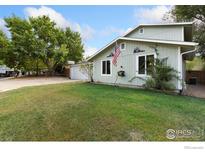 Ranch style home with a well-manicured lawn and attached garage at 927 Quartz Ct, Longmont, CO 80504