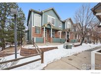 Brick and teal townhome exterior with snow-covered landscaping at 2855 Rock Creek Cir # 311, Superior, CO 80027