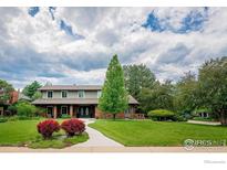 Brick house with a landscaped lawn and walkway at 6916 Hunter Pl, Boulder, CO 80301