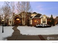 Brick home with a snow-covered front yard and walkway at 7172 Waterford Ct, Niwot, CO 80503