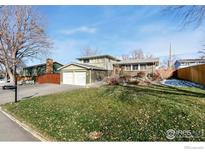 Ranch-style home with a two-car garage and well-maintained lawn at 10596 Ura Ln, Northglenn, CO 80234