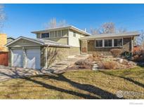 Charming two-story brick home with an attached two-car garage and well-maintained front yard landscaping at 10596 Ura Ln, Northglenn, CO 80234