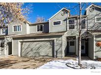 Two-story townhome with attached garage and snow-covered landscaping at 11277 Holly St, Thornton, CO 80233