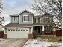 Two-story house with gray siding, brick accents, and a double-car garage at 2010 E 99Th Pl, Thornton, CO 80229