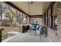 Inviting front porch with brick columns and comfortable seating at 402 11Th N Ave, Longmont, CO 80501