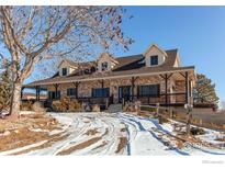 Brick home with a large porch and expansive yard at 420 E County Road 10, Berthoud, CO 80513