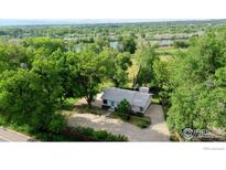 Aerial view of ranch style home with large yard, river, and mountain views at 6903 Valmont Rd, Boulder, CO 80301