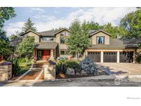 Beautiful exterior featuring a three-car garage, brick accents, manicured landscaping, and an inviting front entrance at 7035 Rustic Trl, Boulder, CO 80301