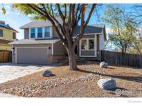 Two-story house with gray siding, attached garage, and landscaping at 10579 Cherry St, Thornton, CO 80233