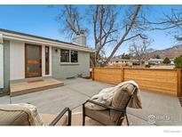 Charming exterior featuring a well-manicured yard and patio area with mountain views at 1310 Toedtli Dr, Boulder, CO 80305