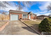 Brick ranch house with attached garage and landscaped front yard at 1373 E 110Th Pl, Northglenn, CO 80233