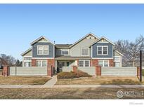 Inviting two-story townhome featuring a well-maintained front lawn and charming architectural details at 13900 Lake Song Ln # 2, Broomfield, CO 80023