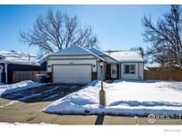 Nice curb appeal with a two-car garage and snow-covered lawn at 1621 Flemming Dr, Longmont, CO 80501