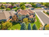 Beautiful aerial view of a manicured property, a mature neighborhood, and tree-lined streets at 1644 Stardance Cir, Longmont, CO 80504