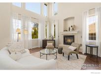 Bright living room featuring a fireplace, large windows, and elegant decor at 1644 Stardance Cir, Longmont, CO 80504